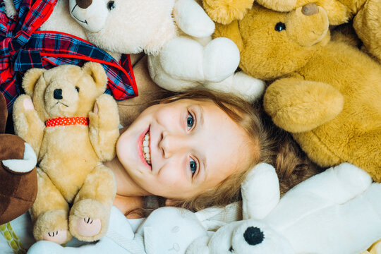 Toys dream. Kid girl dreams near tiys teddy. Childhood dream. Daydreamer child. Dreams and imagination. Dreamy kids. Child hugging teddy bear. Kid funny face near toys.