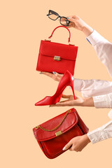 Female hands with stylish women's bags, eyeglasses and high heels on beige background - obrazy, fototapety, plakaty