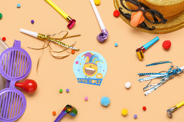 Hat with funny glasses, party whistles and decor on beige background. April Fool Day