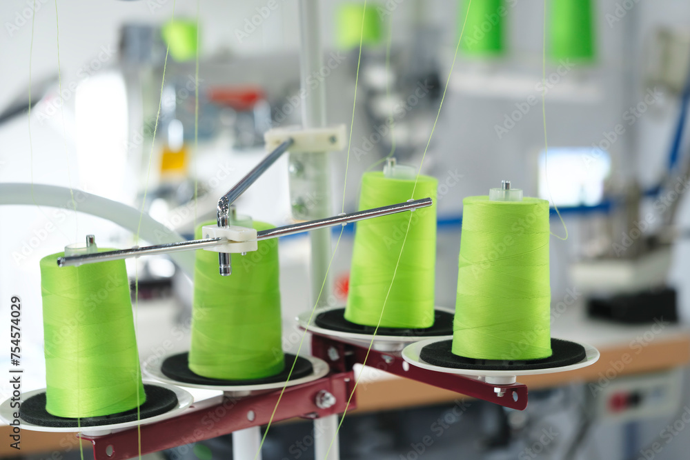 Aufkleber spools of color threads closeup, spinning machine