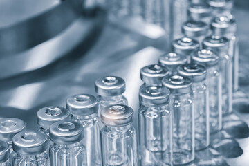 Pharmaceutical industry. Production line machine conveyor with glass bottles ampoules at factory....