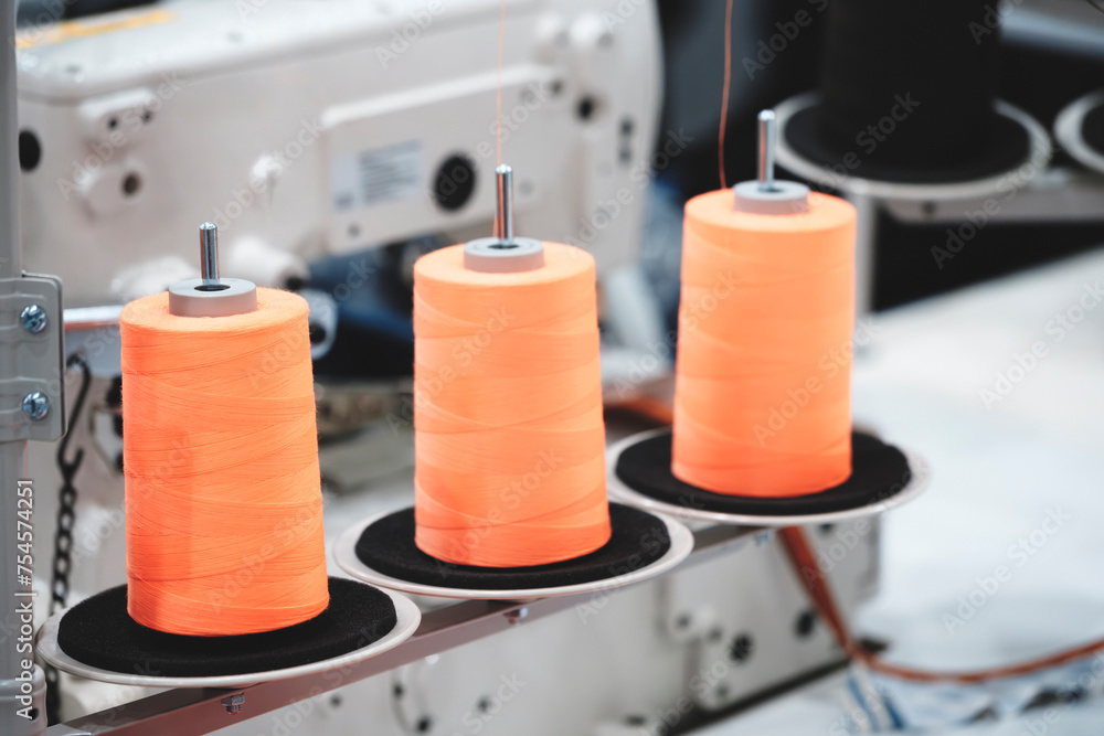 Aufkleber spools of color threads closeup, spinning machine
