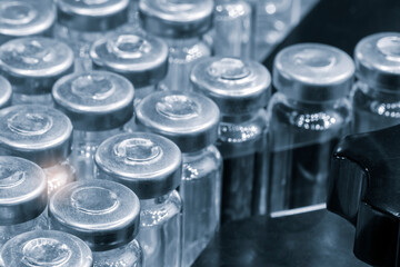 Pharmaceutical industry. Production line machine conveyor with glass bottles ampoules at factory. Pharmaceutical industry concept background.