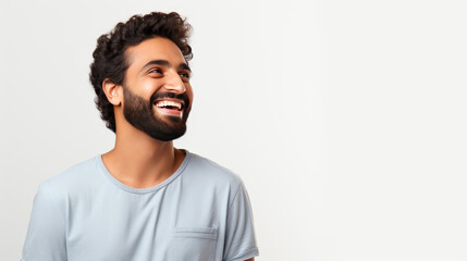 Joyful man with a beard and curly hair, laughing and looking away against a white background. - obrazy, fototapety, plakaty
