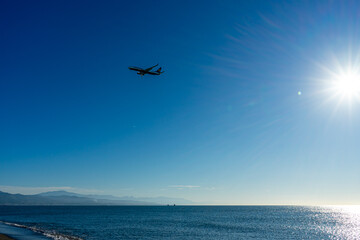 Airplane landing at sunrise over Mediterranean Sea, Costa del Sol in Malaga, Spain