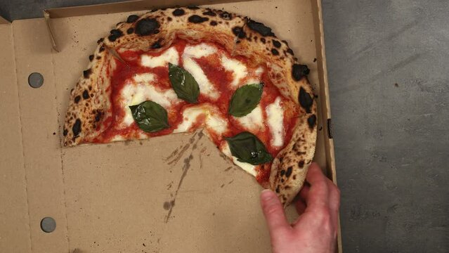 Best owen baked italian pizza margherita eaten right from delivery paper box. Top view, 4K stop motion animation.