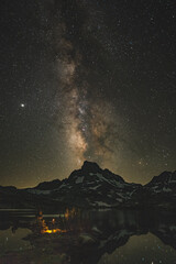 Astrophotography with person holding lighter with the milky way galaxy in the sierra mountains.