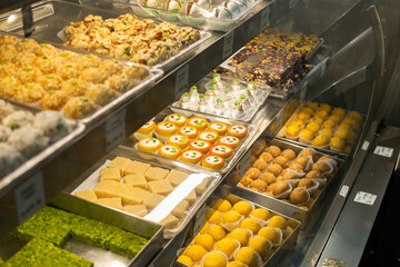 Traditional Indian sweets and desserts in pastry shop and street food on markets