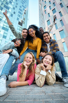 Vertical. A group of happy people is sharing a fun moment. Young friends take a selfie picture during a leisure event. The team is traveling together. Smiling community portrait looking at camera
