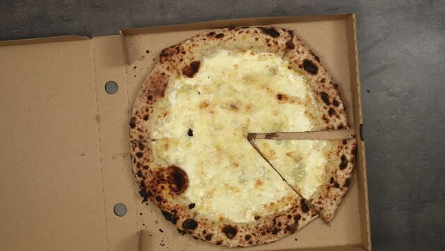 Best owen baked italian pizza qiattro formaggi eaten right from delivery paper box. Top view, 4K stop motion animation.