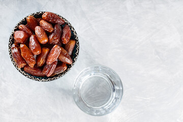 Bowl of Dates and Water on Gray background, Islamic Religion and Ramadan Concept, Copy Space