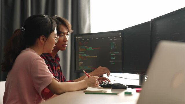 Back end software developer engineer for computer programming working together on debugging writing computing code, solving complex algorithms display on monitor in office. Burgeoning