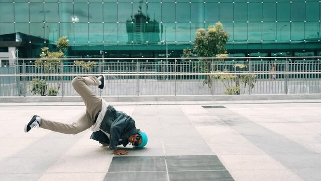 Happy hipster listen to hip hop music from headphone while dancing in lively mood. Professional street dancer perform b boy dancing at outdoor. Outdoor sport 2024. Modern lifestyle. Sprightly.