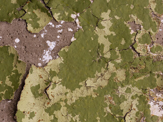 Green peeling paint on the wall. Old concrete wall with cracked flaking paint. Weathered rough...