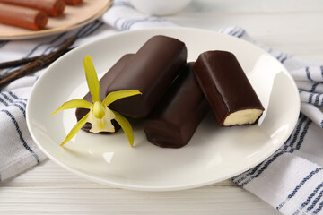 Glazed vanilla curd cheese bars served on white wooden table, closeup