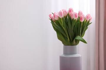 Beautiful bouquet of fresh pink tulips indoors. Space for text
