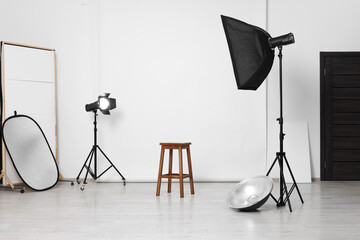 White photo background, stool and professional lighting equipment in studio