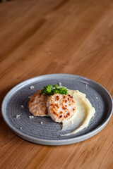2 cutlets and mashed potatoes, beautifully decorated with herbs.
