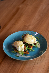 Poached eggs on a Belgian waffle with arugula leaves, healthy food for breakfast.