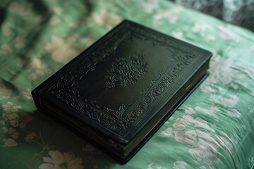 Fototapeta premium a black hardcover book with a green cover, in the style of victorian engravings, textured shading, symmetrical arrangement