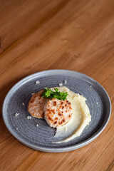 2 cutlets and mashed potatoes, beautifully decorated with herbs.