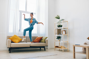 Joyful Woman Jumping in a Happy Home: A Playful Concept of Indoor Relaxation