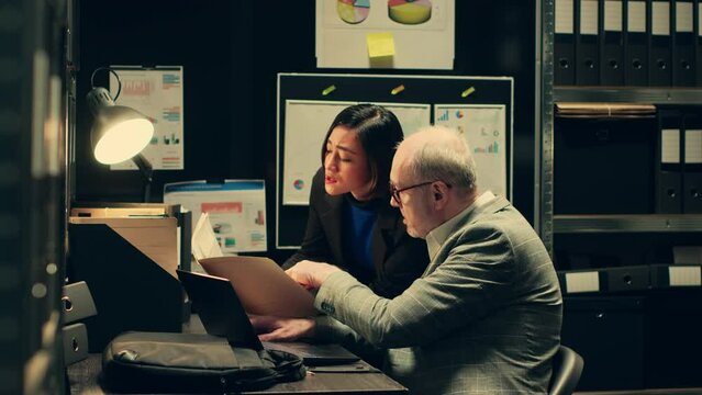 Detective team examines archived files for crucial case evidence, working in incident room with classified documents. Inspectors remain relentless in the pursuit of justice, police archive. Camera A.