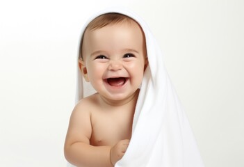 Baby laughs standing wrapped in white towel