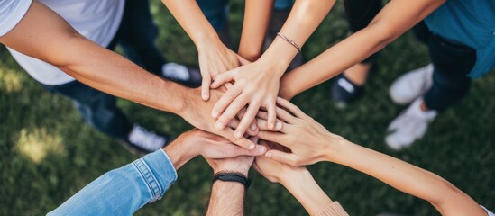 close up of stacked human hands showing working together to build a business.