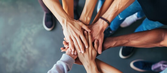 close up of stacked human hands showing working together to build a business.