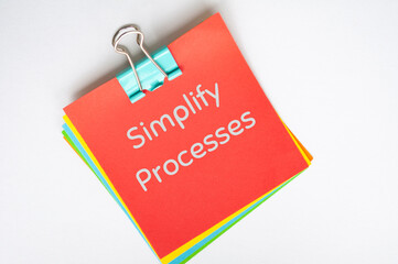 simplify processes text on red notepad on white background