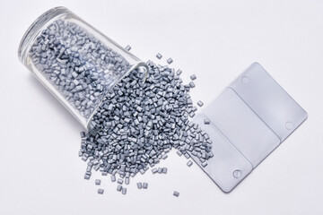 pearl silver masterbatch granules on a white background, equipped with a color chip as an example...