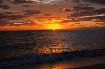 Beautiful clouds over the sea, sunrise. Full ocean beach sunrise with deep golden sky.
