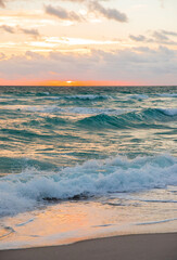 Full ocean beach sunrise with deep golden sky and sun rays
