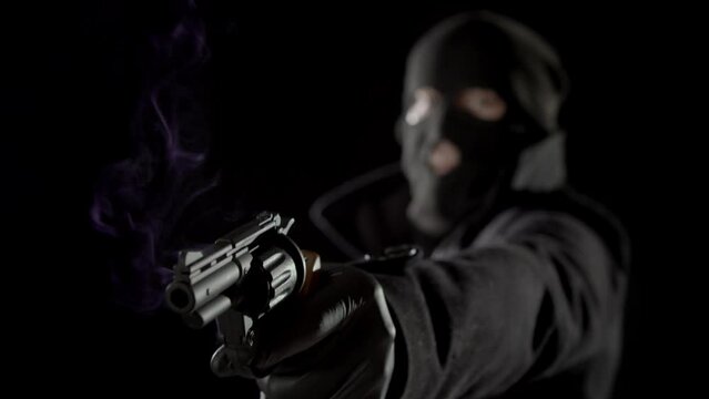 A robber fires a revolver