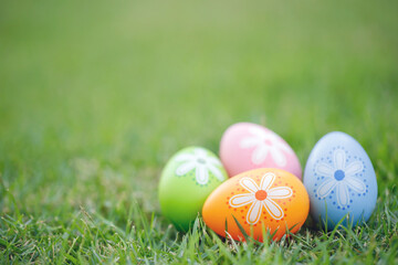 Fototapeta na wymiar Collection of colorful easter eggs on green grass to celebrate Easter or spring.