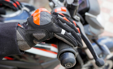woman motorcyclist in motorcycle gloves on a motorcycle close-up