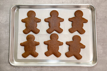Top view of baked gingerbread man cookies on a baking sheet.