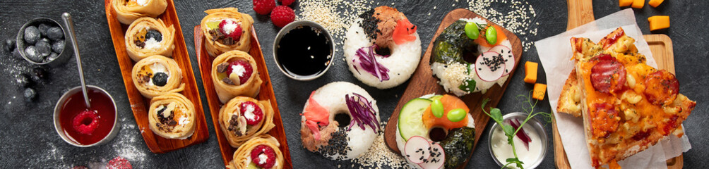 Hybrid trendy food on dark background. Sushi roll pancake, donut sushi, pizza with pasta