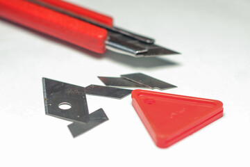 cutter knife with cut blade and tools for cutting with a white background and from a top angle