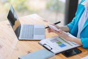 Asian accounting woman working with document paper and laptop computer at table office, Financial and accounting woman concept.  - obrazy, fototapety, plakaty