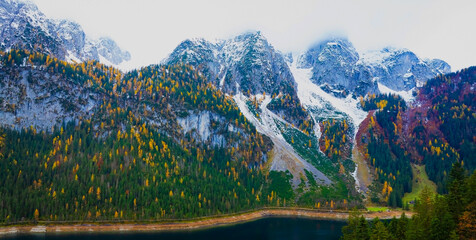 Gosausee with Dachstein mountain summit and blue lake as idyllic colorful autumn scenery background