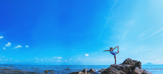 Asian women relax in the holiday. Travel relax.  Play if yoga. On the rocks by the sea. In the summer. Thailand - 754696062