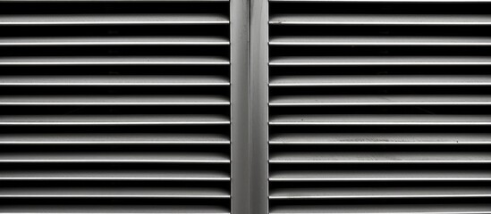 A black and white photograph showcasing a metal grille with a striped texture, serving as a protective street ventilation system. The intricate iron grates, grey steel grating, and blinds add depth to