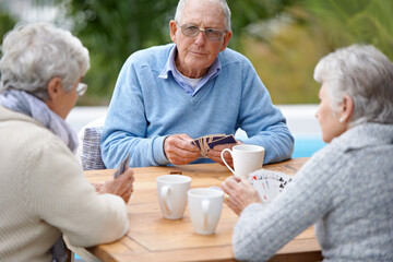 Poker, playing cards and senior group in retirement, outdoor and relaxed in garden, backyard and...