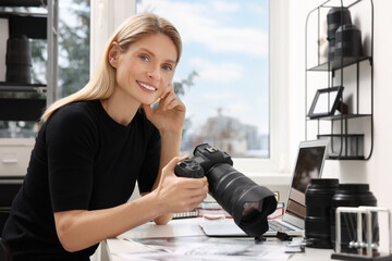 Professional photographer with digital camera at table in office