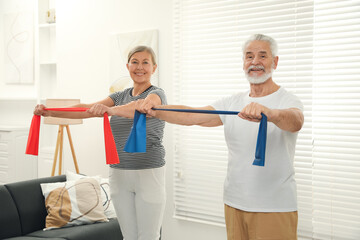 Senior couple doing exercise with fitness elastic bands at home