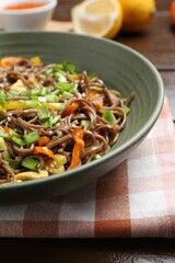 Stir-fry. Delicious cooked noodles with chicken and vegetables in bowl on table, closeup