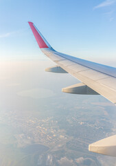 View from the airplane window at a beautiful cloudy sky and the airplane wing