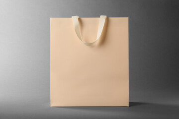 One paper bag on grey background. Mockup for design - 754727842